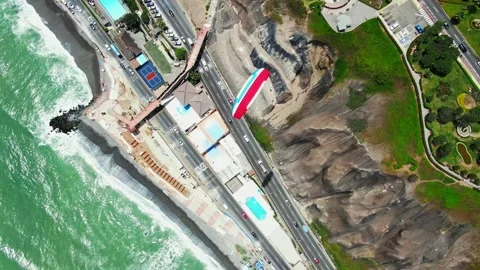 Top-down aerial drone tracking a paraglider over the Costa Verde highway Vidéo 348624707