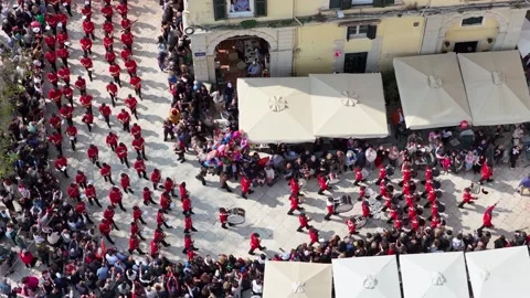 Top down aerial drone video of a musical marching band in vibrant red uniforms Stock Footage 333783837