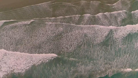 Top down Aerial drone view of waves coming in to the beach. Slow pull up. Stock Footage 110938875