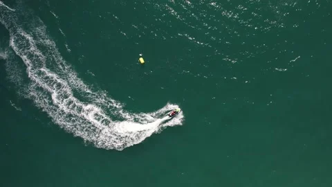 Top down aerial drone view of fast jetskier making a curve leaving a wake  Stock Footage 239525018