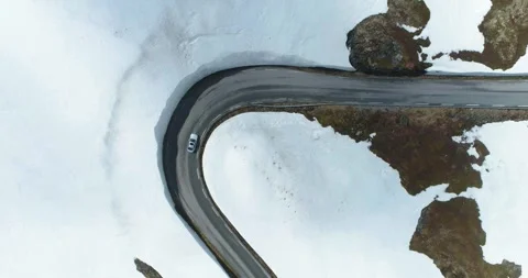 Top Down Aerial Drone View of Snow Covered Mountains and Road in Norway Stock Footage 247378148