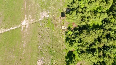 Top-down aerial drone view of cable lift gondola crossing mountain meadow Stock Footage 312593425