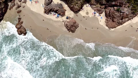 Top Down Aerial Drone View of Beachgoers and Waves at Rocky Sandy Cove Stock Footage 329314642