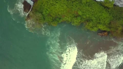 Top Down Aerial Drone View of Ocean Waves Crashing Against Lush Tropical Cli Stock Footage 329434612