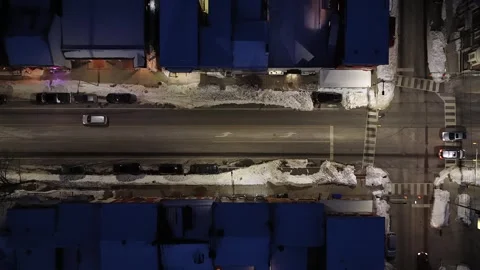 Top down aerial drone view of snowy downtown street intersection at night, with Stock Footage 334374547