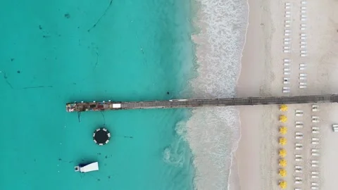 Top down aerial drone view of a long stone pier jetty stretching into 스톡 동영상 336695593