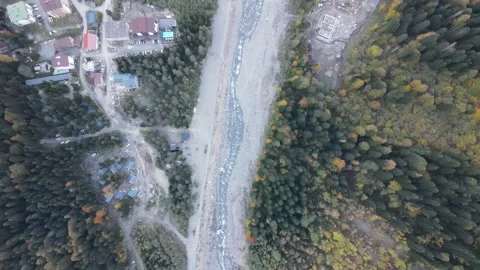 Top-down aerial drone view of a mountain river flowing through a village Stock Footage 337529054