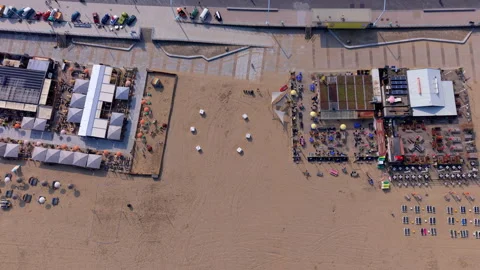 Top-down aerial drone view of vibrant sandy beach clubs in Scheveningen Stock Footage 337910495