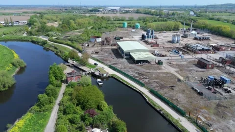 Top-down aerial drone view of chemical storage tanks and safety bund walls in Stock Footage 346653154
