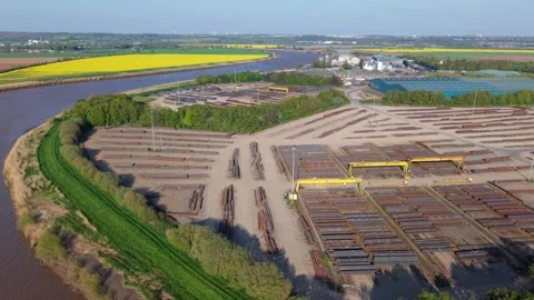 Top-down aerial drone view of stacked structural steel beams and coils on a Stock Footage 346653302