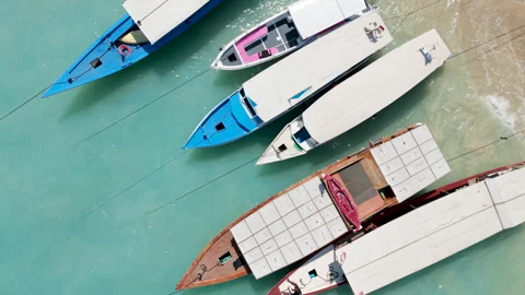Top Down Aerial Drone View of Wooden Boats Gently Rocking in Turquoise Water Stock Footage 346799380