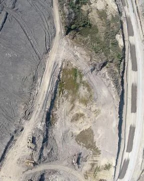 Top-down aerial drone view of an active mining site with heavy machinery Stock Photos