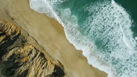 Top down aerial of emerald ocean water, sand and stone cliffs near San Francisco Stock Photos