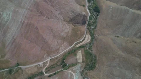Top-down aerial of eroded Chalus Road hillsides with a pale track crossing dry Stock Footage 343907432