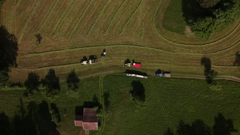Top down aerial of farmer entering tractor during hay harvesting work 動画素材 334570370