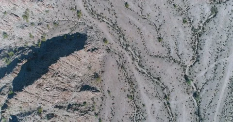 Top down aerial flight over rocky hill and gully erosion in harsh desert ter Stock Footage 147240164