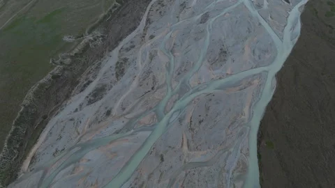 Top-down aerial flight over braided glacial river channels, Kyrgyzstan Видео 347241076