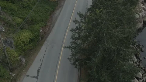 Top down aerial of grey van driving along seaside road Stock Footage 154655364