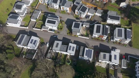 Top-down aerial of grid of pale angular homes with rooftop solar panels framed Video stock 310599807