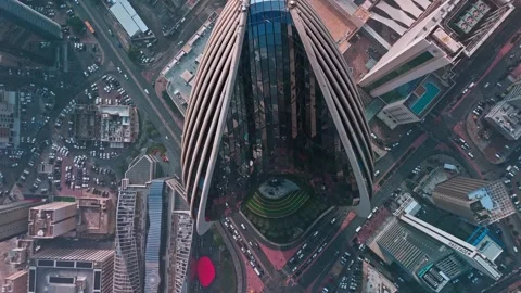 Top-Down Aerial of Iconic Skyscraper Roof with Curved Facade above Dense Stock Footage 324890265