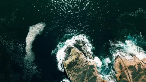 Top-down aerial of ocean waves crashing on coastal rocks Stock Footage 339186950