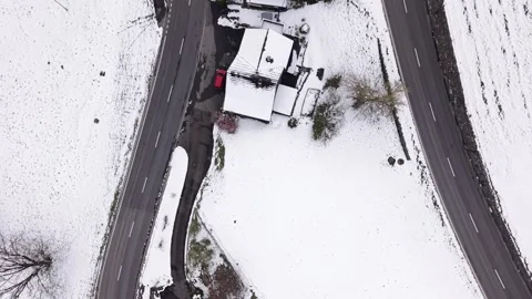 Top Down Aerial Over Mountain Houses and Hairpin Road With Cars in Snow Видео 331588678