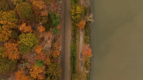 Top down aerial over train tracks autumn foliage reveal Bear Mountain Bridge NY Stock Footage 119382738