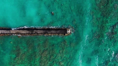 Top-Down Aerial of Pier Extending Into Clear Turquoise Ocean Stock Footage 325631131