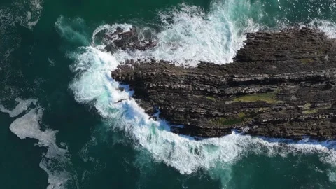 Top-down aerial of powerful waves crashing over a rocky point, Portugal Stock Footage 346377619