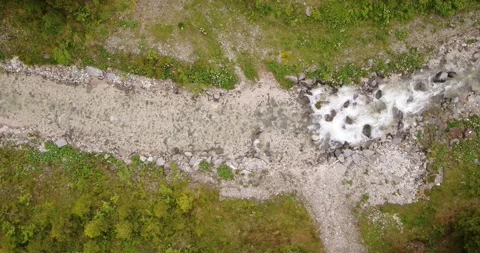 Top down Aerial of river in the Alps. Water flowing down a small river in Italy Stock Footage 146584849