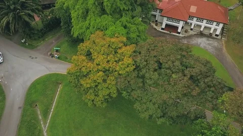 Top-down aerial shot of a blue taxi driving pass an old house in a park Stock Footage 108801854
