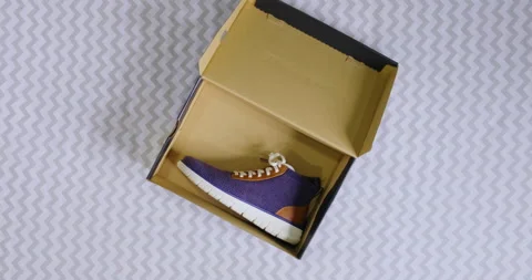 Top down aerial shot of a man taking his autumn fall boots out of a shoe box Stock Footage 204046491