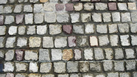 Top down aerial shot moving forward over an ancient rough cobbled stone pavement Stock Footage 341903484