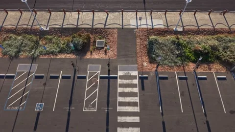 Top-down aerial shot of parking lot with accessible and EV spaces Vidéo 345019833