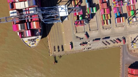 Top down aerial shot of stacked shipping containers and cargo vessels berthed Vídeos de archivo 342080694