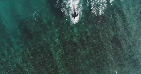 Top down aerial shot on surfers catching waves at the ocean. Bird eye view high Stock Footage 123651663
