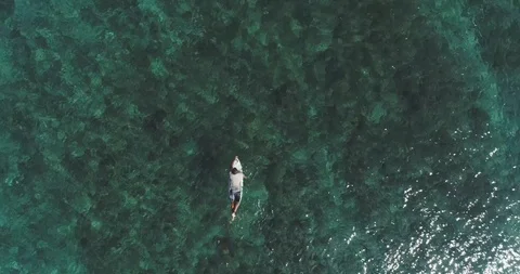 Top down aerial shot on surfers catching waves at the ocean. Bird eye view high Stock Footage 123700061