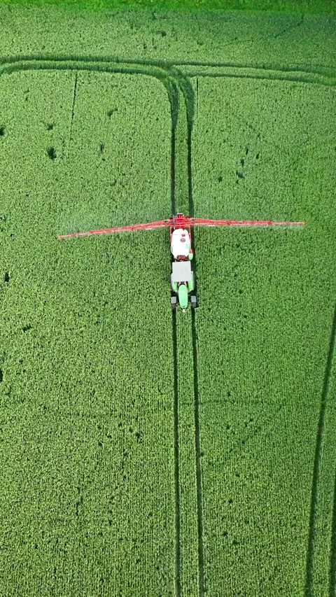 Top Down Aerial Shot Of Tractor Spraying Pesticides On Green Field Video stock 328942630