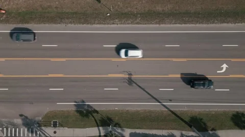 Top down aerial shot of a two way 5 lane road with traffic moving in both Vídeo Stock 233855264