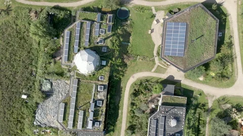 Top down aerial of solar panels on rooftops on beautiful earthship homes Stock Footage 139710709