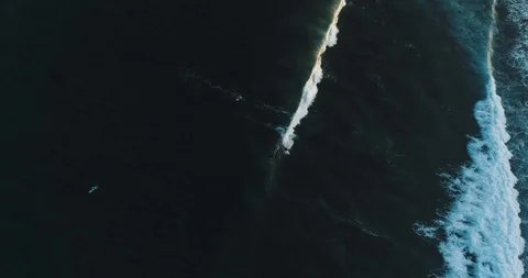 Top Down Aerial tracking shot on skilled male surfer riding a huge wave on a Stock Footage 125329918