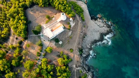 Top-down aerial tracking shot of a church and lighthouse in Spetses, Greece Stock Footage 142720561