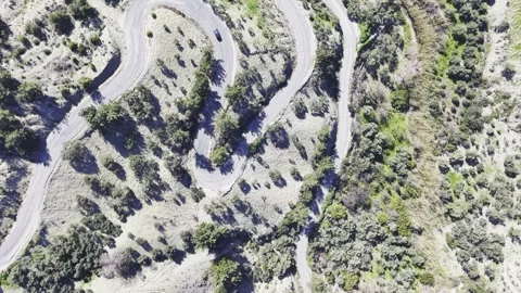 Top-Down Aerial Tracking Shot of Solitary Car on Winding Road - 4K Stock Footage 331776300