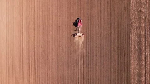 Top-Down Aerial Tracking Shot of Tractor Seeding Large Agricultural Field Stock Footage 334817106