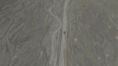 Top-down aerial tracking shot of an SUV on a plateau track, Kyrgyzstan Stock Footage 347241709