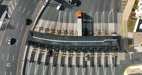 Top down aerial of traffic passing through toll plaza booth to pay money Stock Footage 167576330