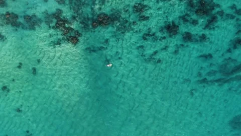 Top Down Aerial of Turquoise Ocean with Surfer Below Stock Footage 325482015