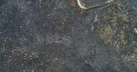 Top Down Aerial Video of Dark Rocky Ground Texture The Concept of Barren Land Stock Footage 323859977
