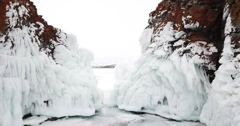 Top down aerial view of 2 ice-bound red rock cliffs in Baikal lake in winter. Stock Footage 140966488