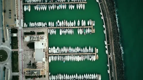 Top down aerial view above luxury yachts parked on turquoise ocean water marina Stock Footage 228714724